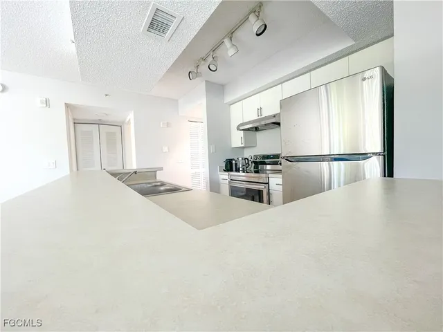 a large white kitchen with cabinets