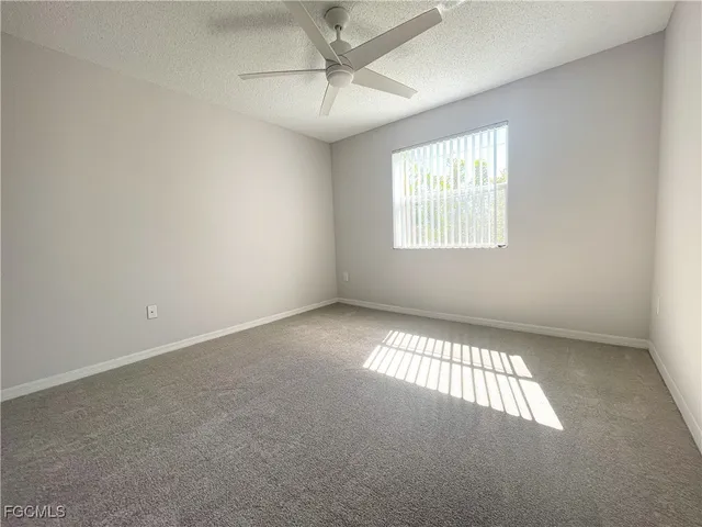 an empty room with a window and a view of a bathroom