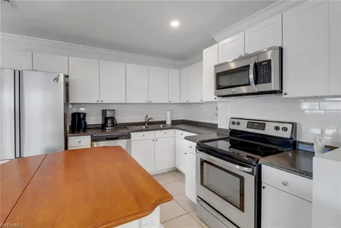 a kitchen with stainless steel appliances a stove microwave and sink