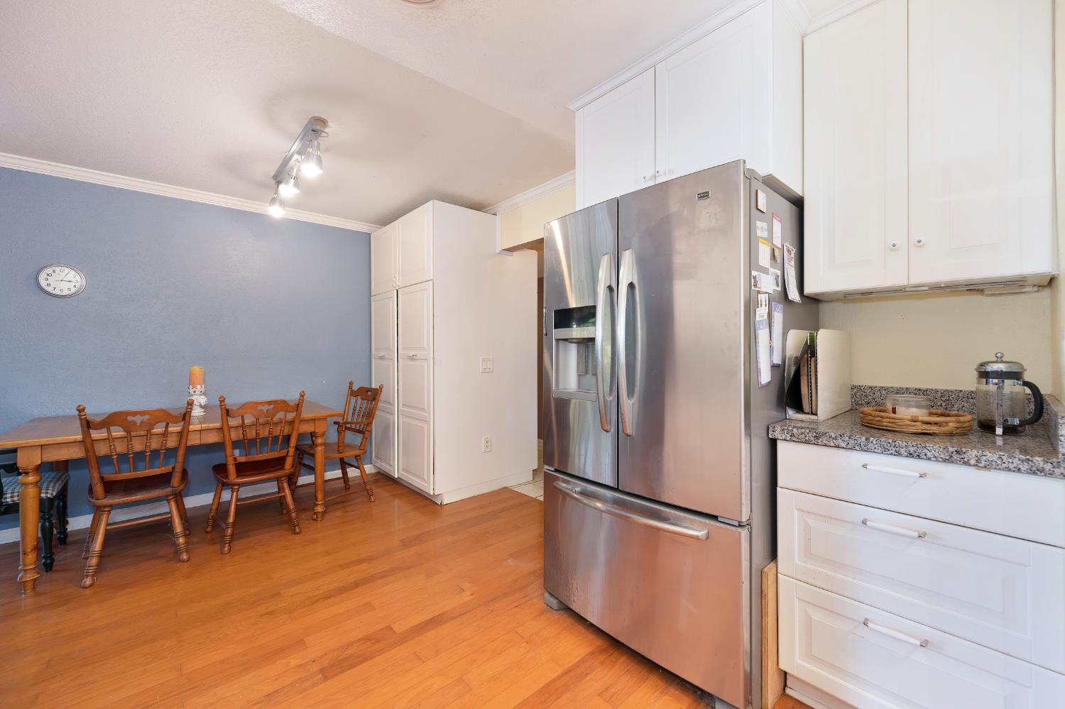 6430 Sandstone Street Carmichael, CA 95608 - Photo 13 of 39 a kitchen with stainless steel appliances a refrigerator a stove a dining table and chairs with wooden floor