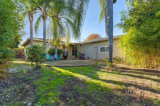 a view of a swimming pool with a patio and a yard