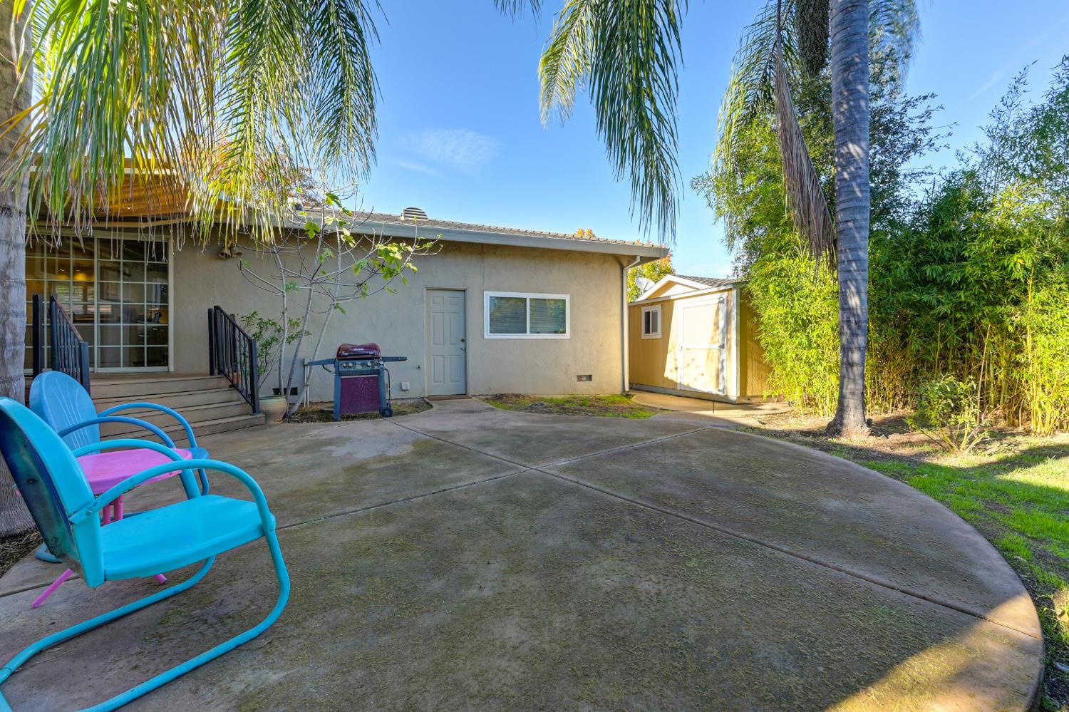 6430 Sandstone Street Carmichael, CA 95608 - Photo 34 of 39 a backyard of a house with table and chairs plants and palm tree