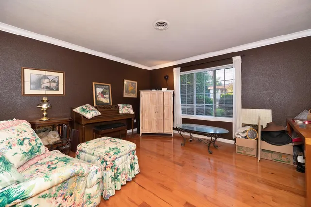 a living room with furniture wooden floor and a kitchen view