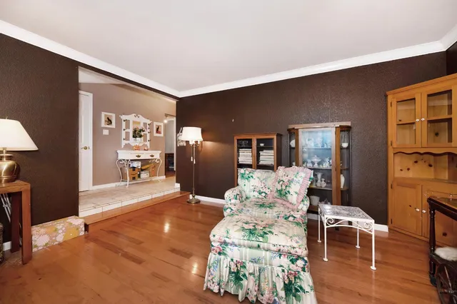 a kitchen with stainless steel appliances granite countertop a stove top oven a sink a dining table and chairs with wooden floor