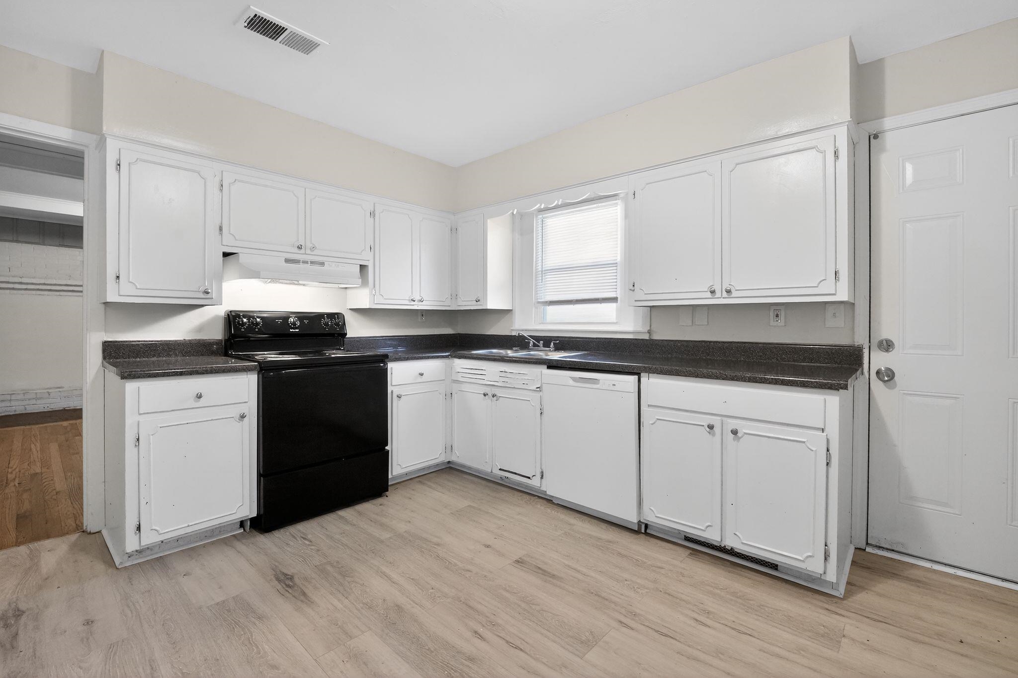 4094 Auburn Road Memphis, TN 38116 - Photo 12 of 30 Kitchen with dark countertops, black electric range, and white cabinetry