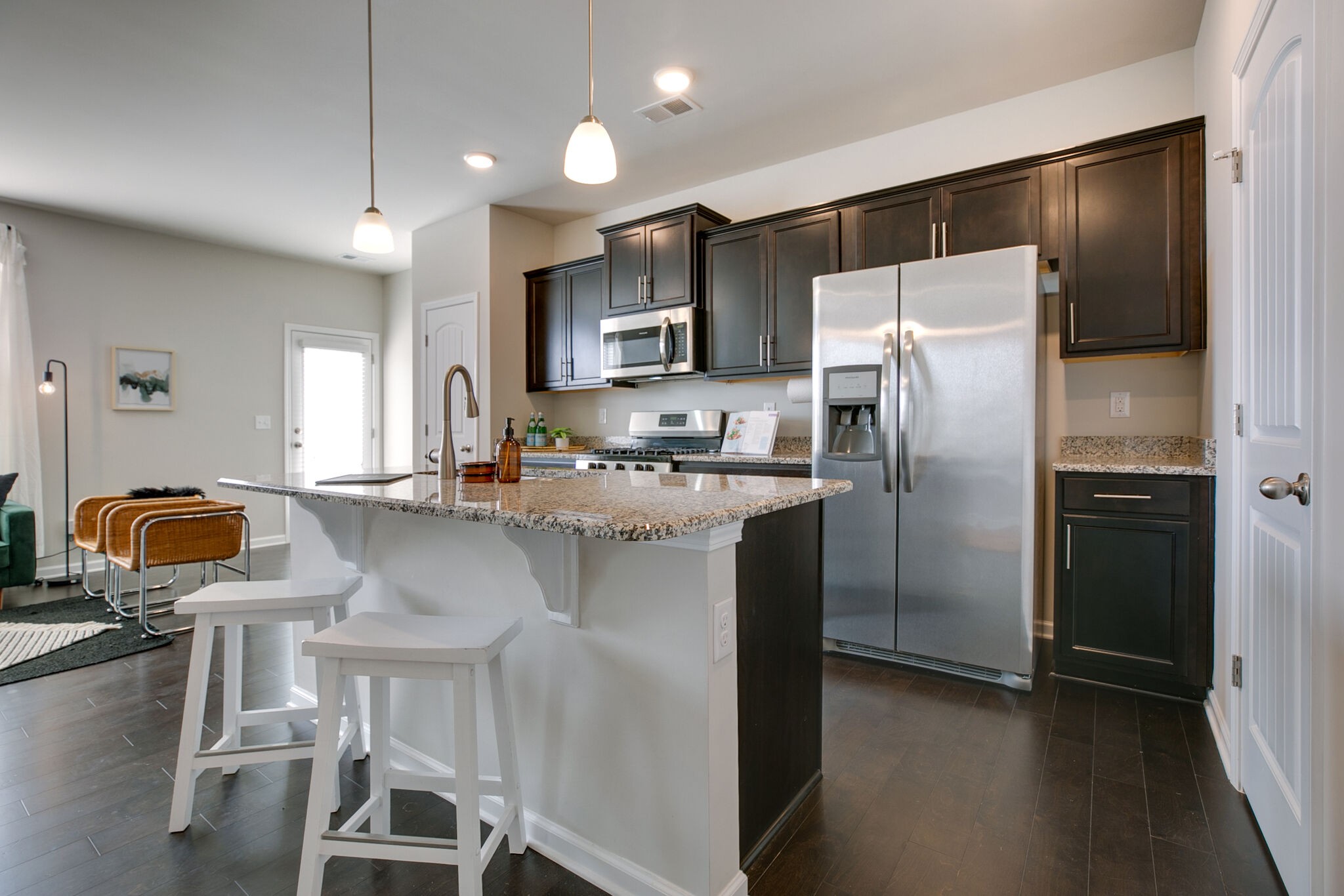 4283 Grapevine Loop Smyrna, TN 37167 - Photo 13 of 30 a kitchen with stainless steel appliances granite countertop a refrigerator a stove a sink a dining table and chairs with wooden floor