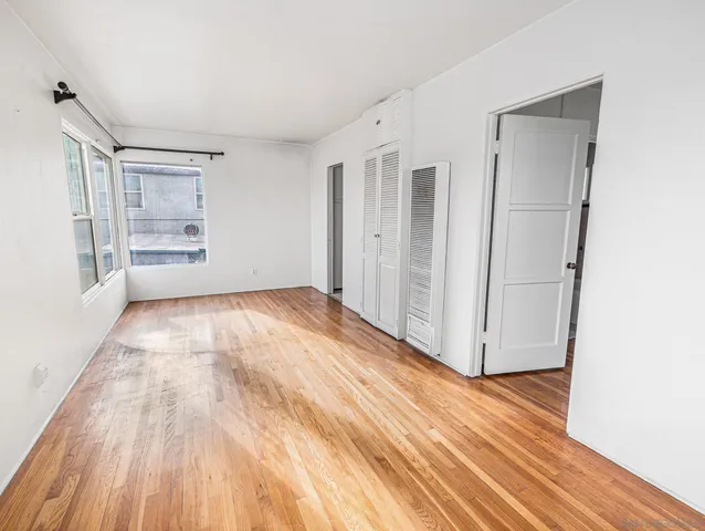 an empty room with wooden floor and a window