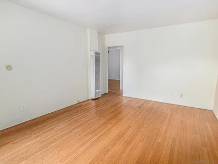a view of an empty room with wooden floor