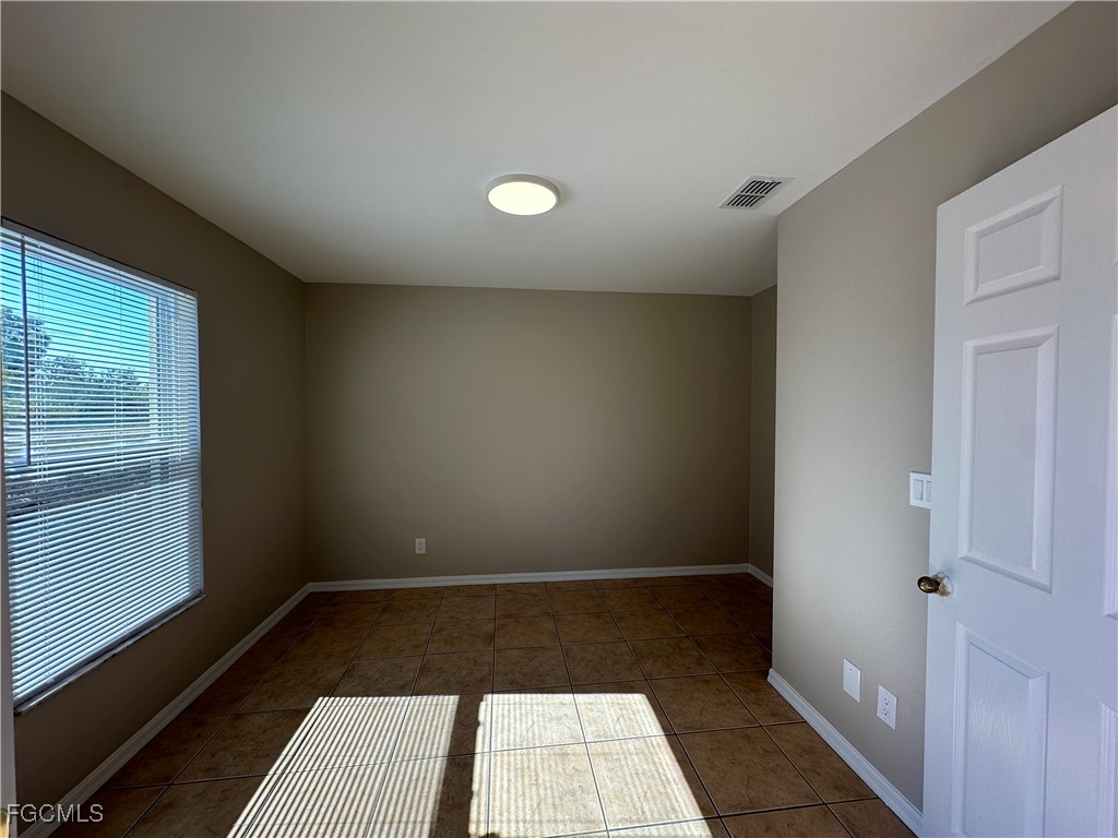 2411 Park Road, Unit 2409 Lehigh Acres, FL 33971 - Photo 5 of 20 wooden floor in an empty room with a window