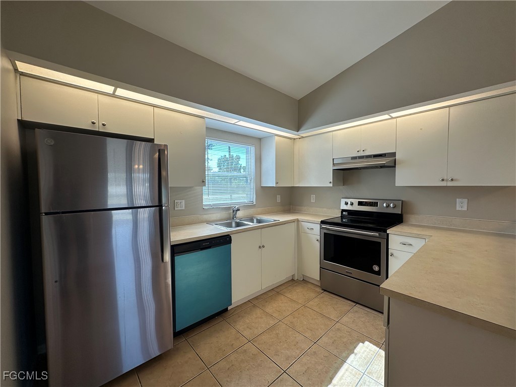 2411 Park Road, Unit 2409 Lehigh Acres, FL 33971 - Photo 7 of 20 a kitchen with stainless steel appliances granite countertop a refrigerator and a sink