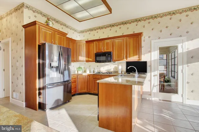 a kitchen with stainless steel appliances granite countertop a refrigerator stove and sink