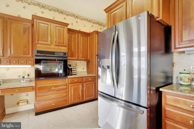 a kitchen with stainless steel appliances granite countertop a refrigerator stove and cabinets