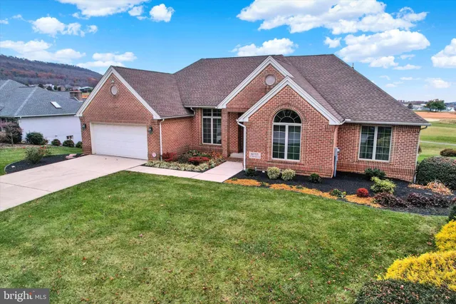 a front view of a house with a garden and yard