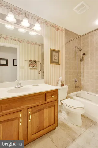 a spacious bathroom with a granite countertop sink a toilet a mirror and bathtub