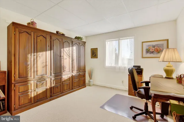 a view of a workspace with furniture and a window