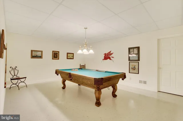 a room with pool table and windows