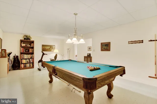a room with pool table and a chandelier