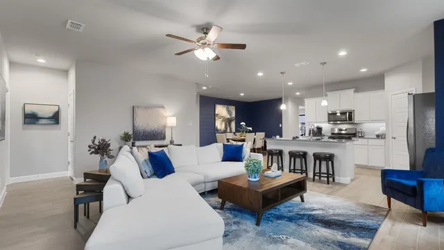 a living room with furniture a flat screen tv and a large window
