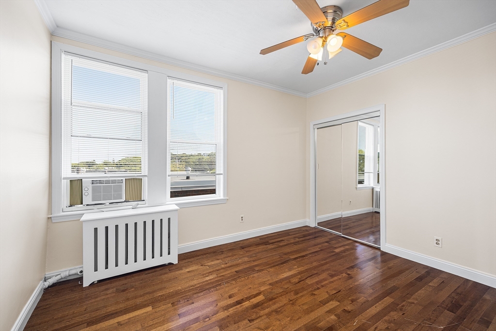 4 Commonwealth Court, Unit 20 Boston, MA 02135 - Photo 13 of 22 an empty room with wooden floor fan and windows