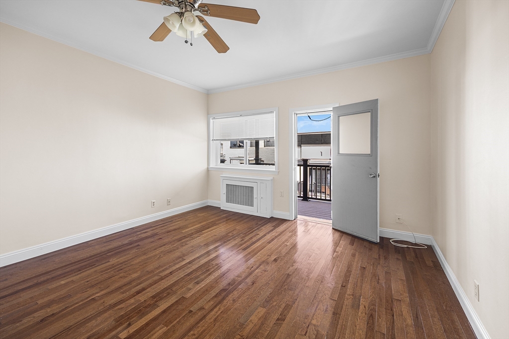 4 Commonwealth Court, Unit 20 Boston, MA 02135 - Photo 2 of 22 an empty room with wooden floor chandelier fan and windows