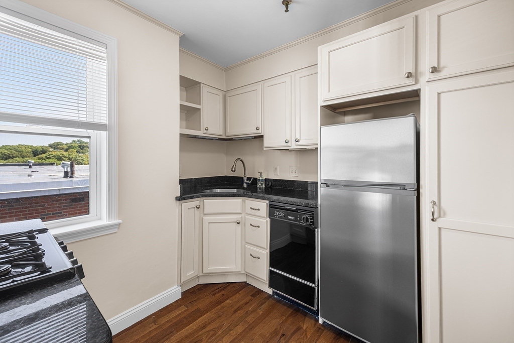 4 Commonwealth Court, Unit 20 Boston, MA 02135 - Photo 8 of 22 a kitchen with a refrigerator stove and wooden cabinets