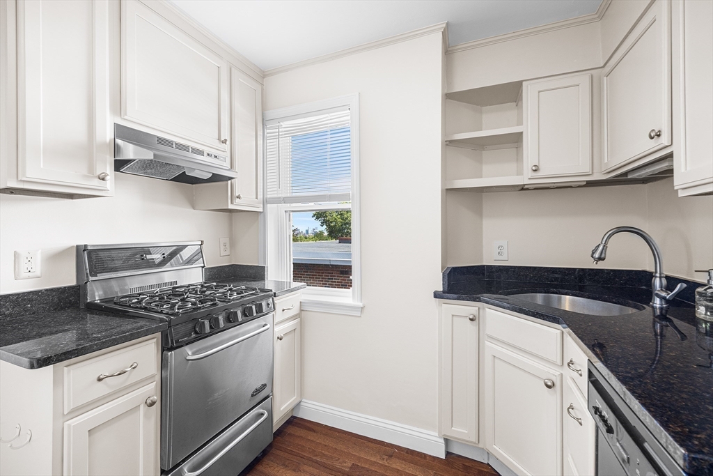 4 Commonwealth Court, Unit 20 Boston, MA 02135 - Photo 9 of 22 a kitchen with white cabinets and appliances