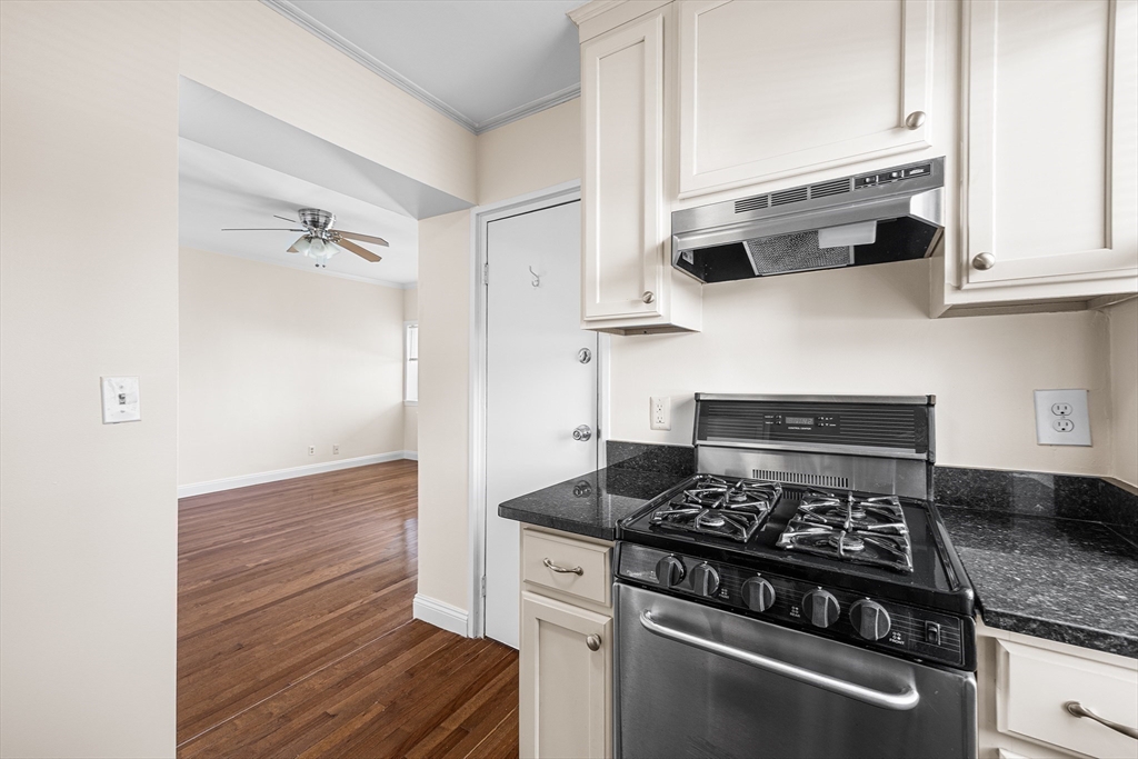 4 Commonwealth Court, Unit 20 Boston, MA 02135 - Photo 10 of 22 a kitchen with stainless steel appliances granite countertop white cabinets and black stove top oven with granite countertops