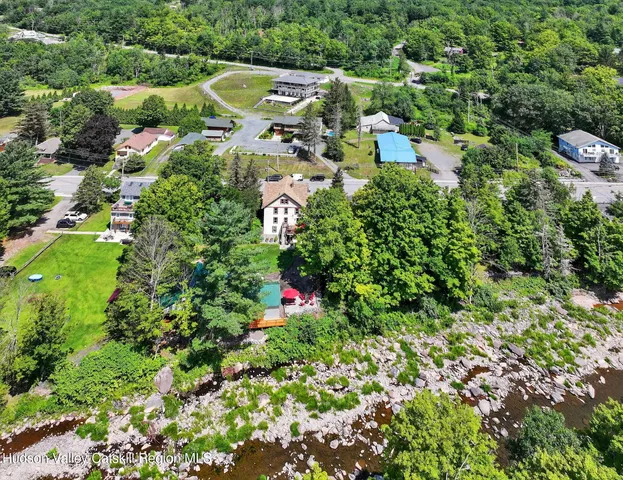 an aerial view of residential house with outdoor space and trees all around