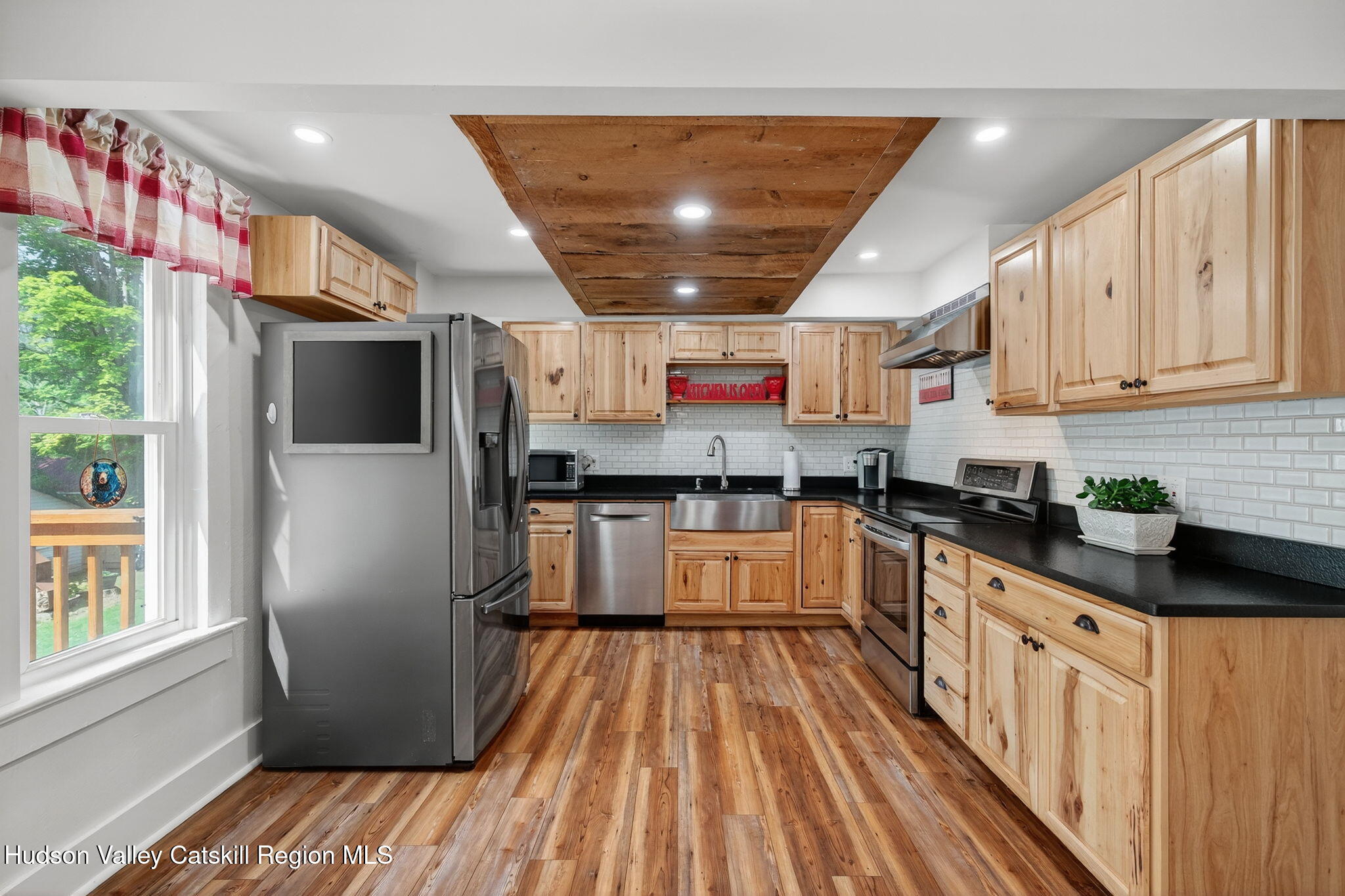 8213 Main Street Hunter, NY 12442 - Photo 5 of 44 a kitchen with stainless steel appliances granite countertop a refrigerator a sink dishwasher a stove and white countertops with wooden floor