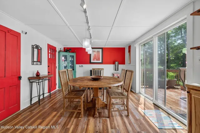 a view of a dining room with furniture a chandelier and wooden floor