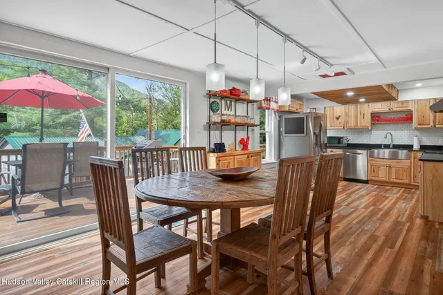 a dining room with stainless steel appliances granite countertop a dining table and chairs with the view