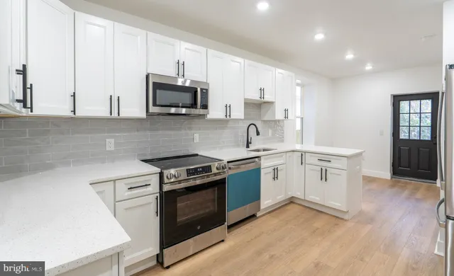 a kitchen with stainless steel appliances granite countertop a stove a sink and a microwave