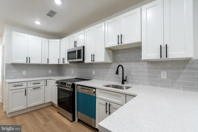 a kitchen with cabinets a sink and appliances