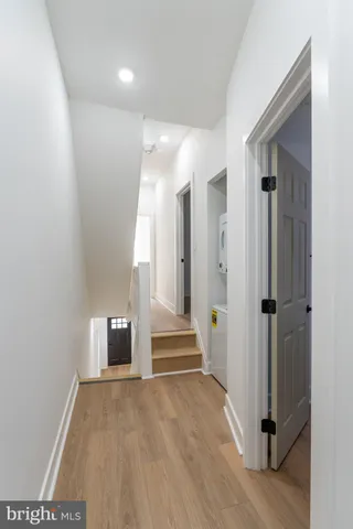 a view of a hallway with entryway and wooden floor
