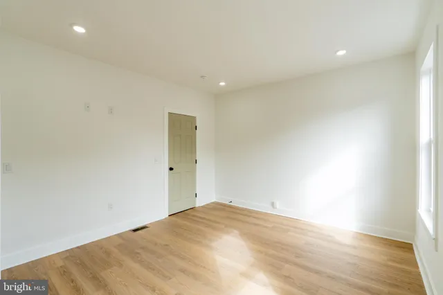 a view of a hallway with wooden floor and entryway