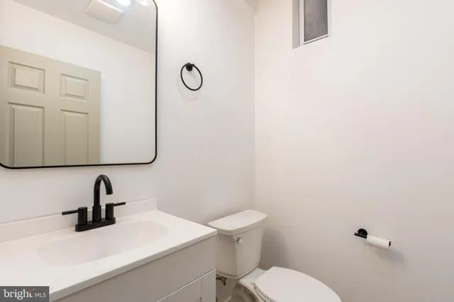 a bathroom with a sink a toilet and a mirror
