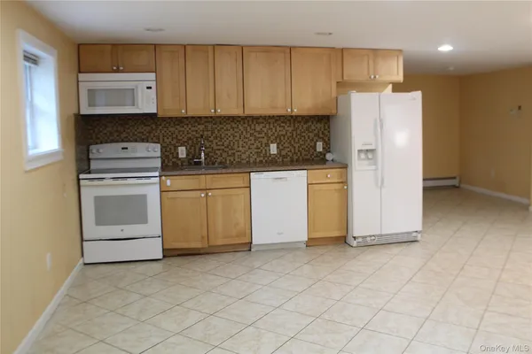 a kitchen with stainless steel appliances granite countertop a stove a refrigerator and a white cabinets