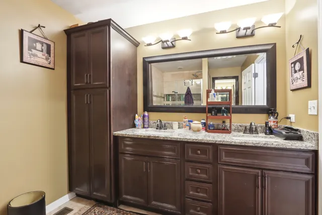 a bathroom with a double vanity sink and a mirror