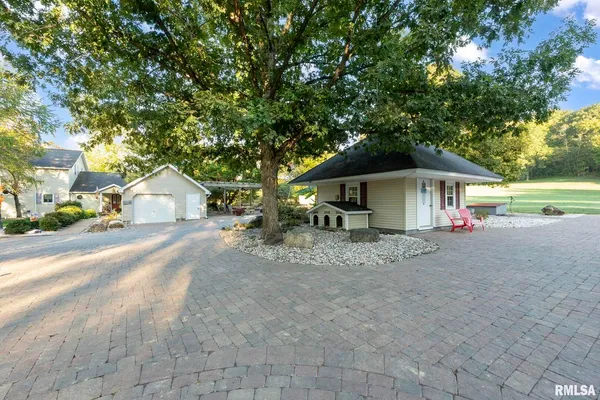 a large kitchen with stainless steel appliances granite countertop a large counter top a stove a chimney a sink and a large window
