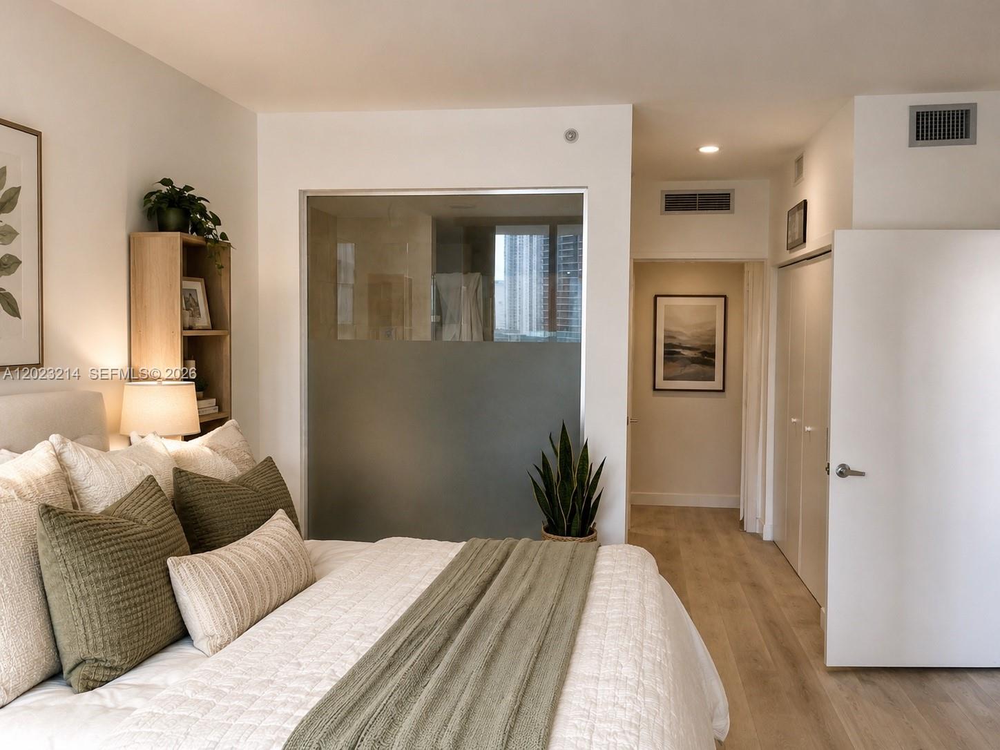 90 Southwest 3rd Street, Unit 2614 Miami, FL 33130 - Photo 7 of 13 a bedroom with a bed and wooden floor
