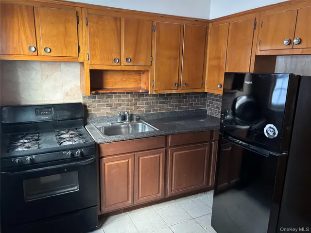 a kitchen with granite countertop a stove top oven microwave and cabinets