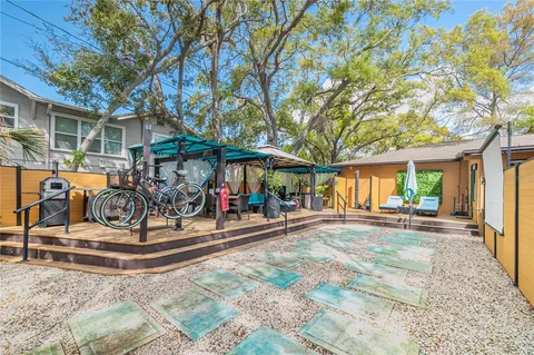 a view of a house with basket ball court and a tree