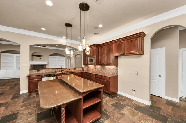 a kitchen with stainless steel appliances granite countertop a sink and a stove