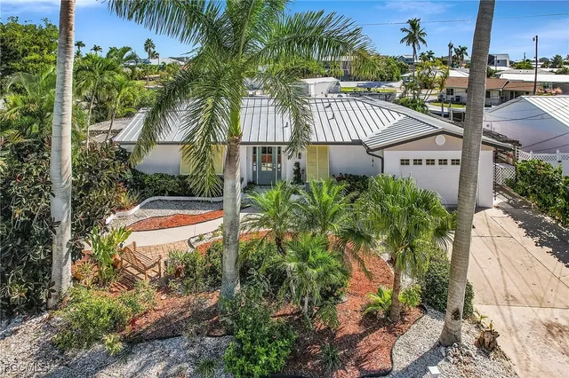 a view of a house with a yard and potted plants