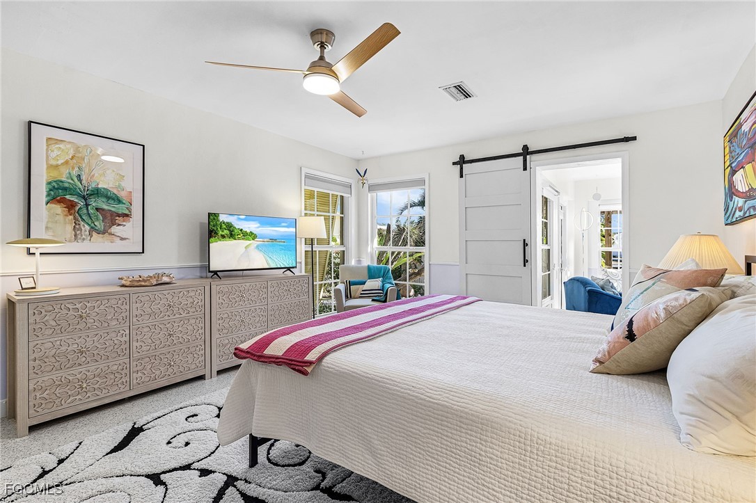 11860 Island Avenue Matlacha, FL 33993 - Photo 16 of 41 a bedroom with a bed and a chandelier