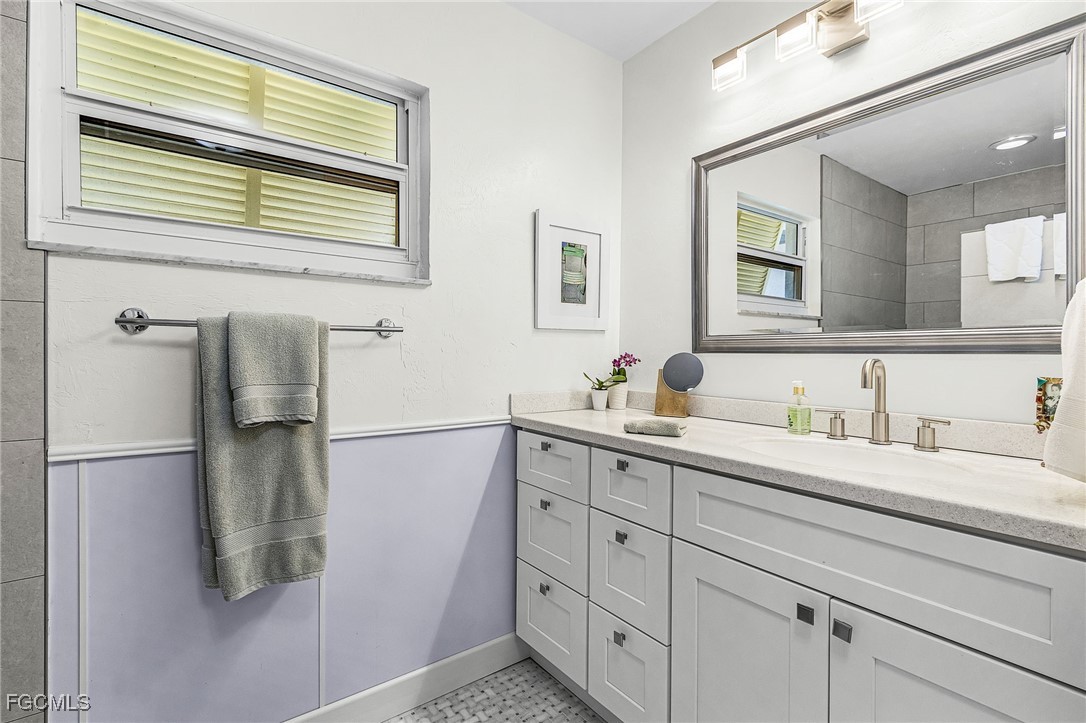11860 Island Avenue Matlacha, FL 33993 - Photo 20 of 41 a bathroom with a granite countertop sink mirror and a shower