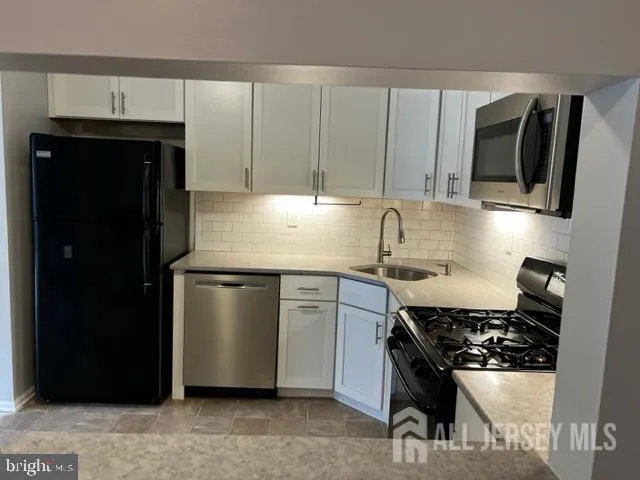 a kitchen with stainless steel appliances a sink stove and refrigerator