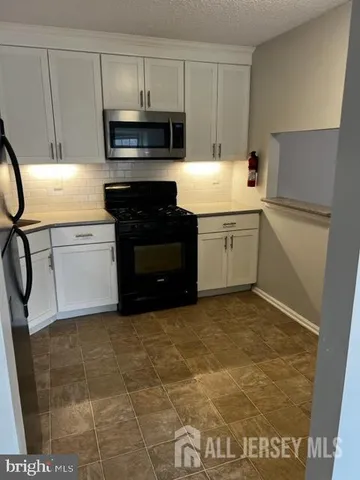 a kitchen with a sink cabinets and appliances