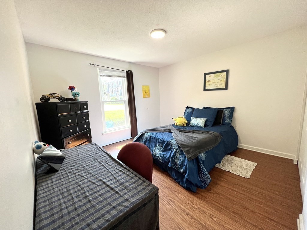 4 Shadowbrook Lane, Unit 6 Milford, MA 01757 - Photo 11 of 16 a bedroom with a bed and wooden floor