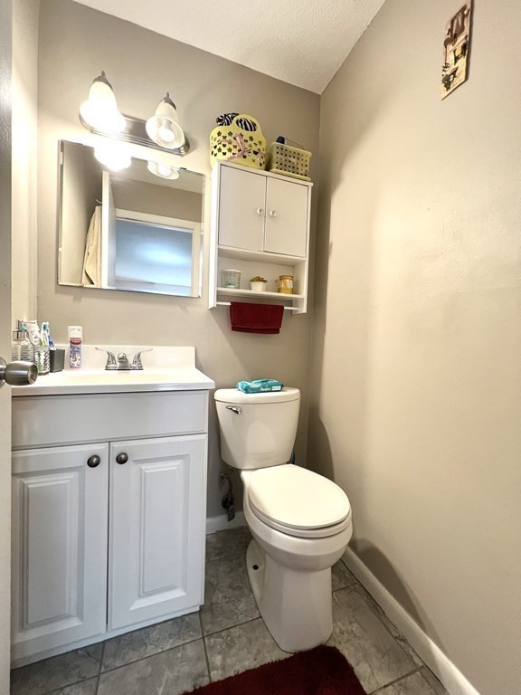 4 Shadowbrook Lane, Unit 6 Milford, MA 01757 - Photo 14 of 16 a bathroom with a toilet a sink and mirror